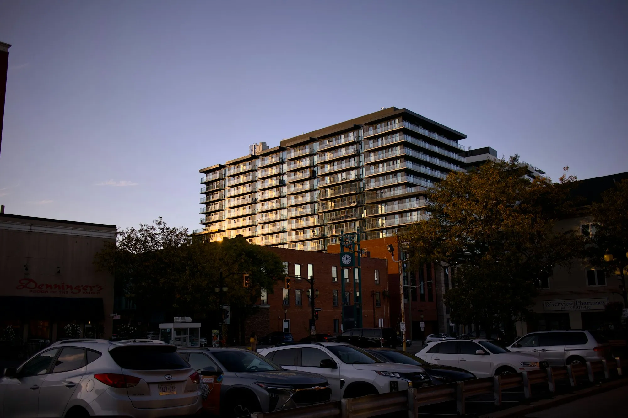 Apartment building at dusk with landscaping and a car park in front