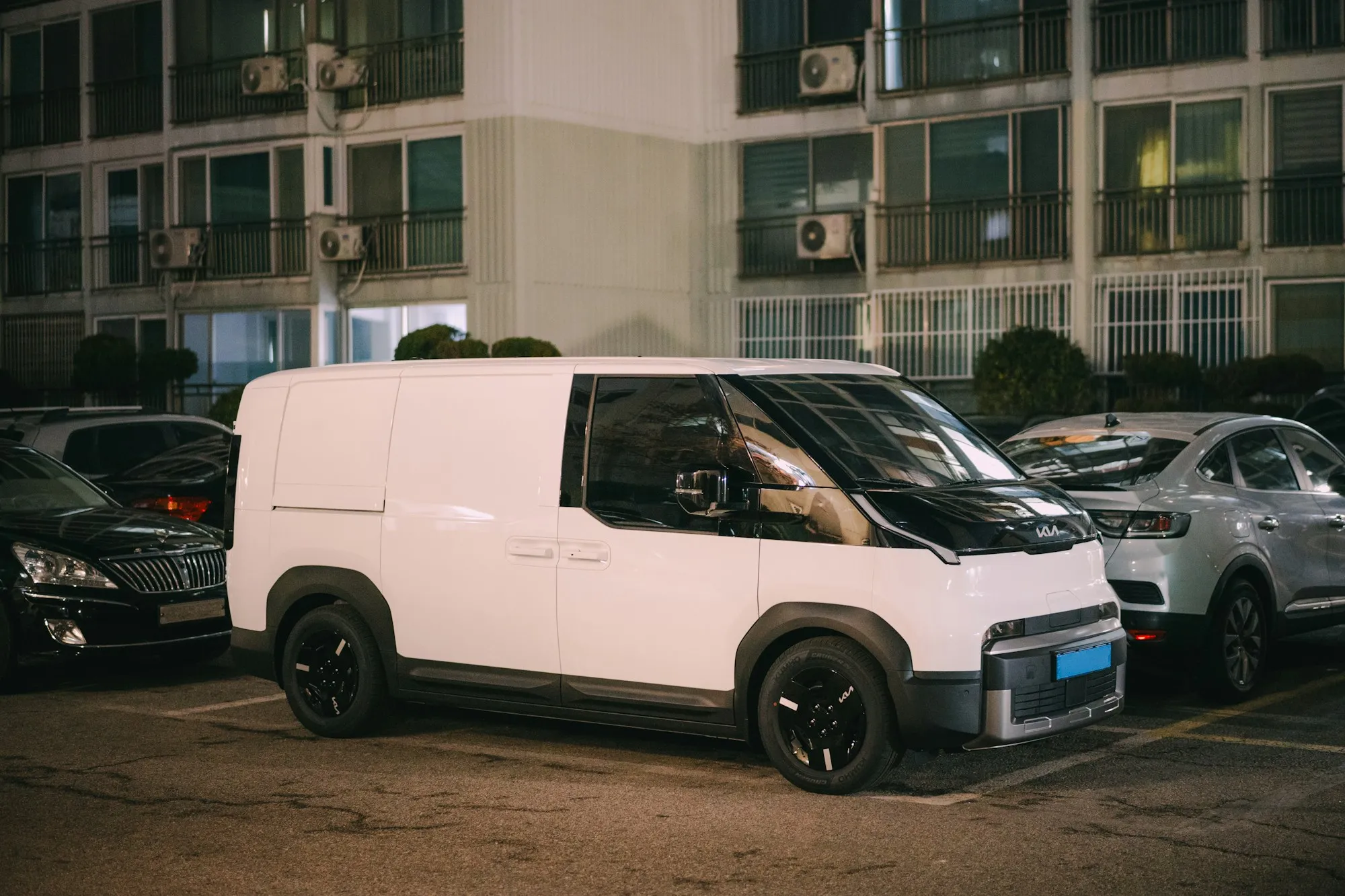 White service van parked outside an apartment building