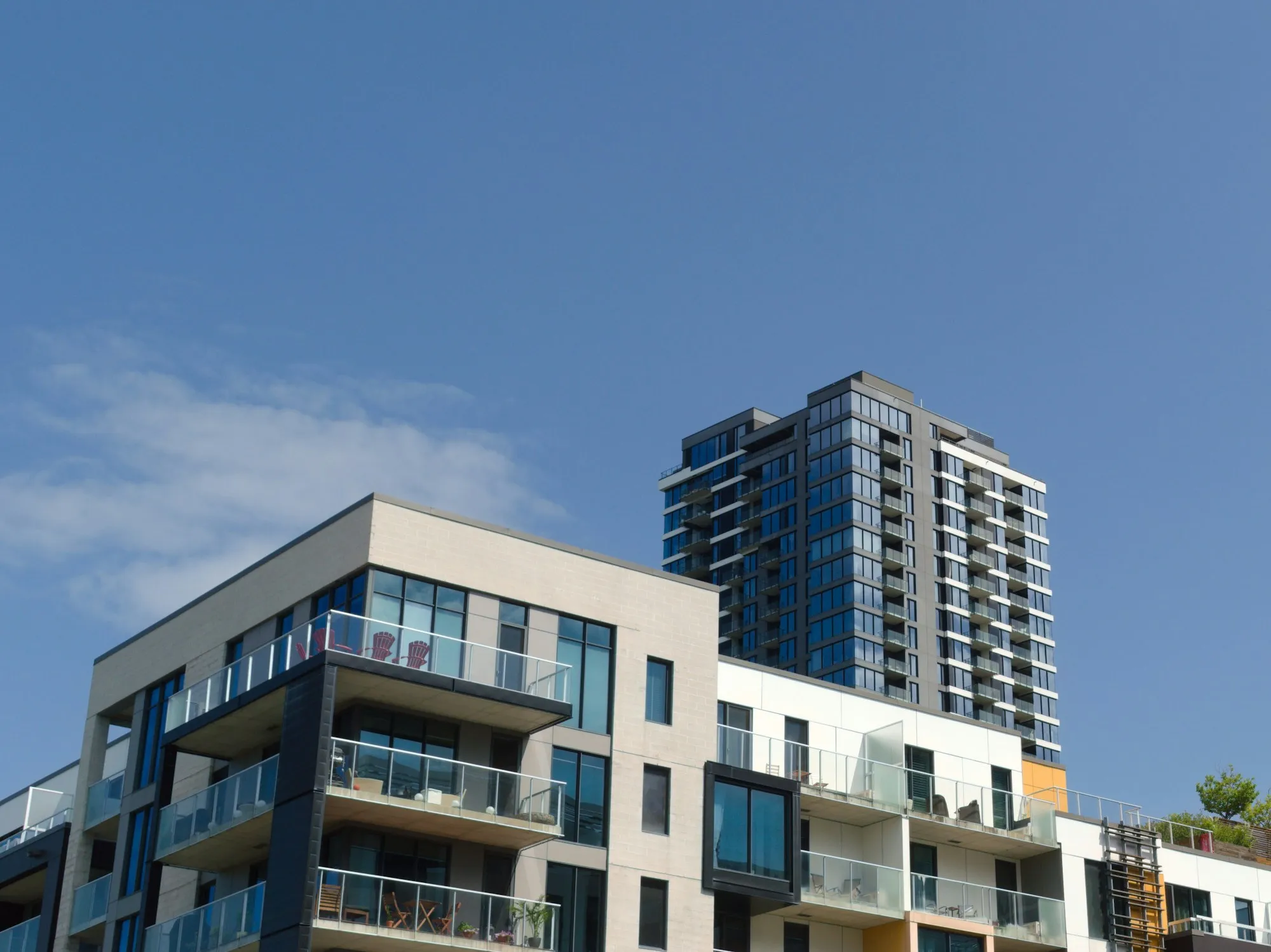 Modern mid-rise strata apartment building with glass balconies